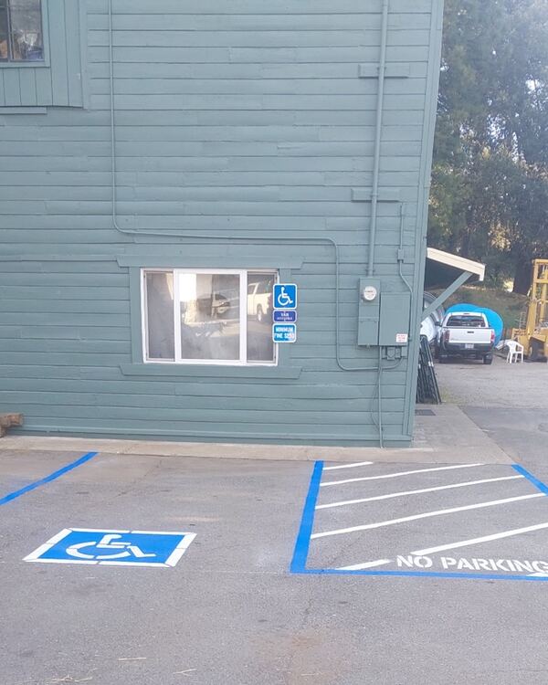 Completed ADA parking stall with blue symbol, crosshatch striping, and No Parking markings — Amador County